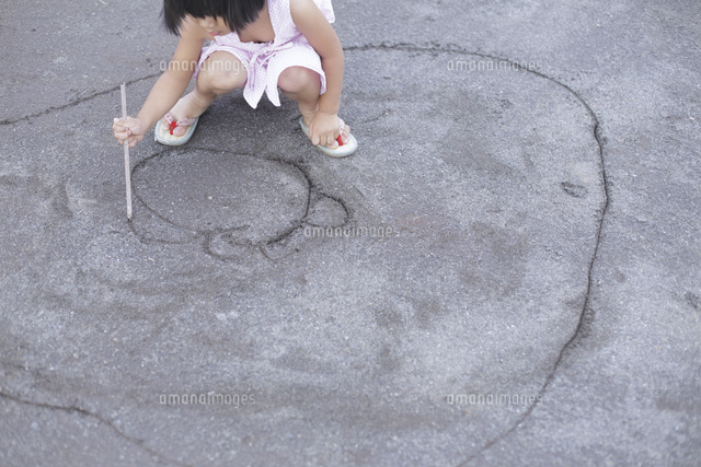 砂の上に絵を描く女の子 の写真素材 イラスト素材 アマナイメージズ