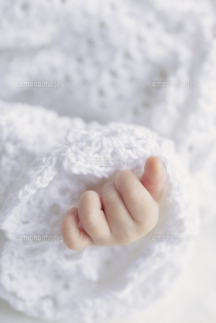 手編みのベビードレスから出る赤ちゃんの手 の写真素材 イラスト素材 アマナイメージズ
