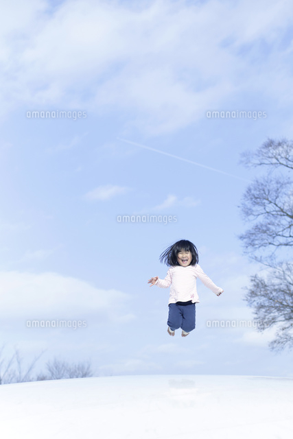 青空の下でジャンプする女の子 の写真素材 イラスト素材 アマナイメージズ
