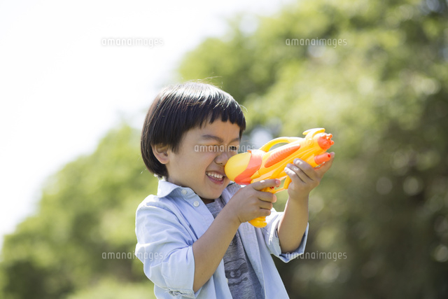 水鉄砲で狙いを定める男の子 の写真素材 イラスト素材 アマナイメージズ