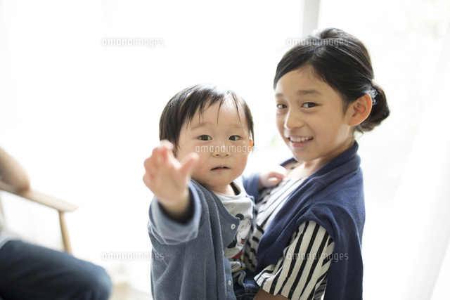 赤ちゃんの弟を抱っこする小学生の女の子 の写真素材 イラスト素材 アマナイメージズ
