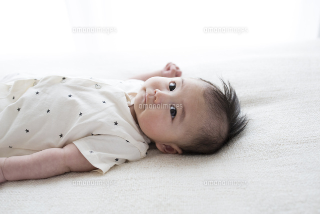 仰向けに寝ている赤ちゃん の写真素材 イラスト素材 アマナイメージズ