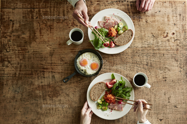 テーブルで食事をする男性と女性 の写真素材 イラスト素材 アマナイメージズ
