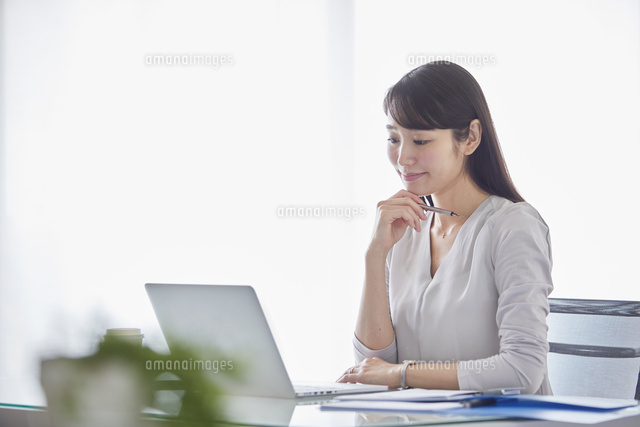 オフィスでパソコンに向かい働く女性 の写真素材 イラスト素材 アマナイメージズ
