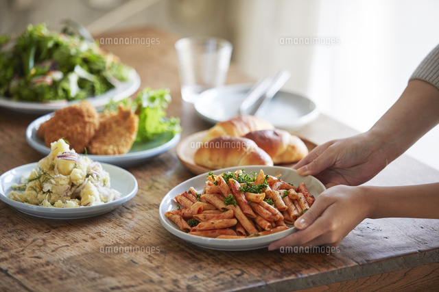 食卓に料理を並べる女性 の写真素材 イラスト素材 アマナイメージズ