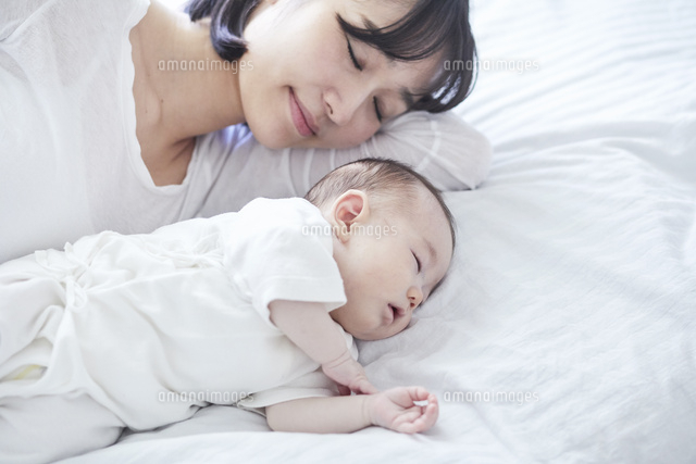 眠る赤ちゃんと添い寝をする母親 の写真素材 イラスト素材 アマナイメージズ