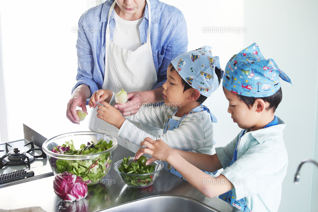 キッチンで料理を作る男の子と女性 の写真素材 イラスト素材 アマナイメージズ