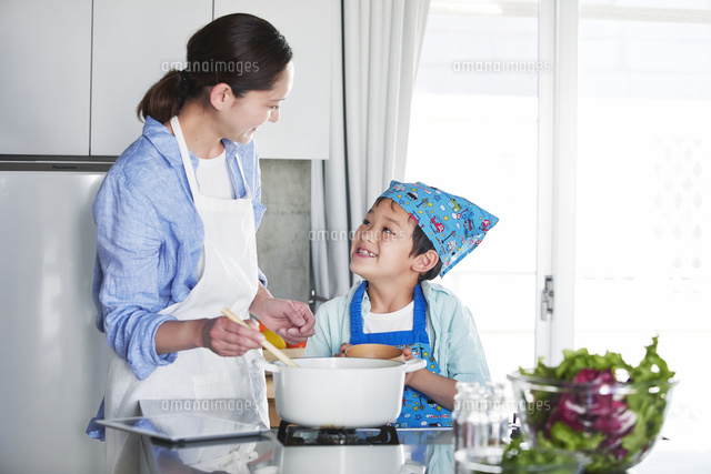 キッチンで料理を作る男の子と女性 の写真素材 イラスト素材 アマナイメージズ