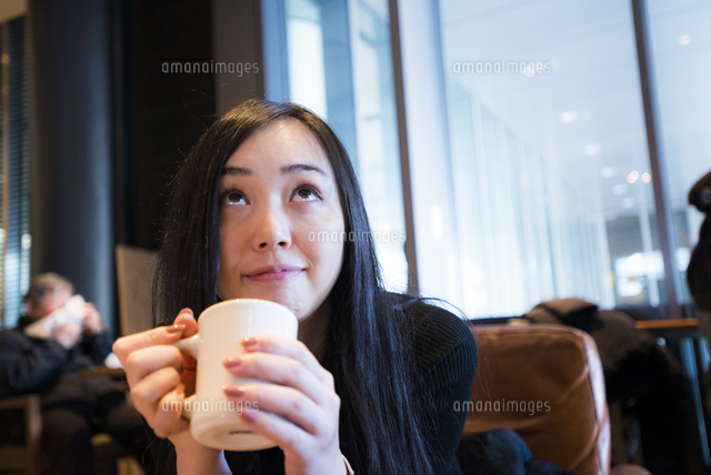 カフェでくつろぎ上を見る女性 の写真素材 イラスト素材 アマナイメージズ
