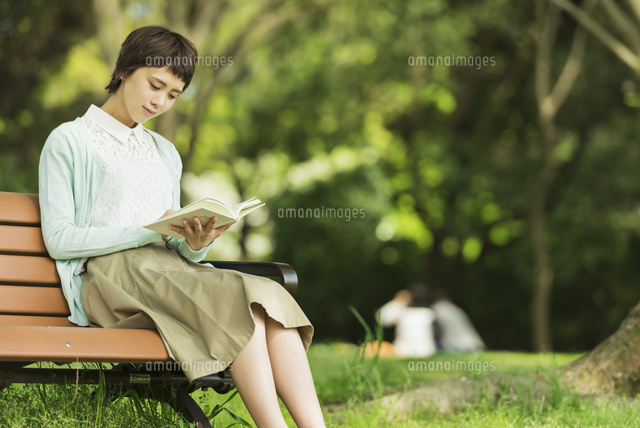 公園で読書する若い女性[10932000396]の写真・イラスト素材｜アマナ