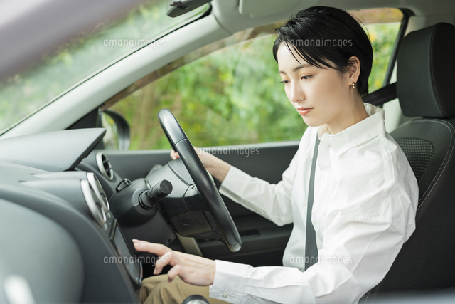 運転中にカーナビを操作する女性 の写真素材 イラスト素材 アマナイメージズ