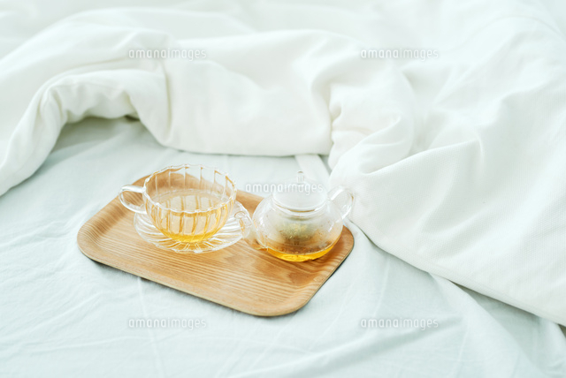 ベッドの上に置かれた紅茶 の写真素材 イラスト素材 アマナイメージズ
