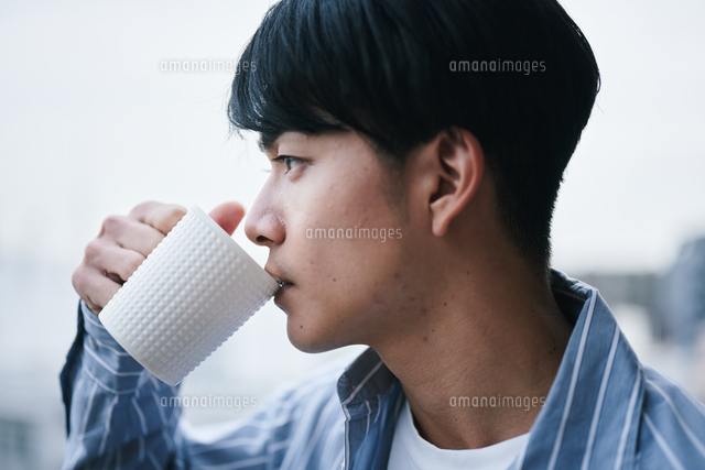 ベランダでコーヒーを飲む男性 の写真素材 イラスト素材 アマナイメージズ