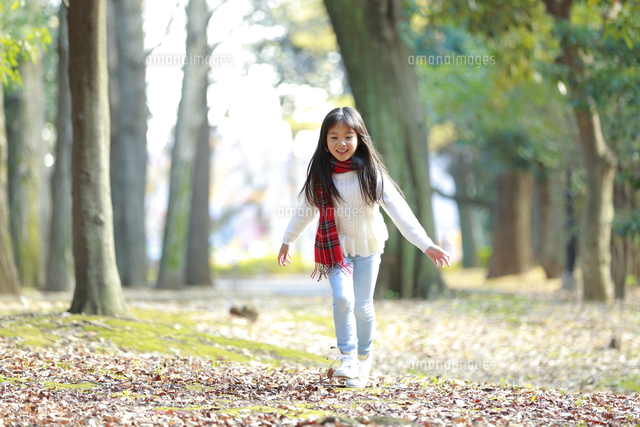 駆け寄る赤いチェック柄のマフラーをつけた少女 の写真素材 イラスト素材 アマナイメージズ