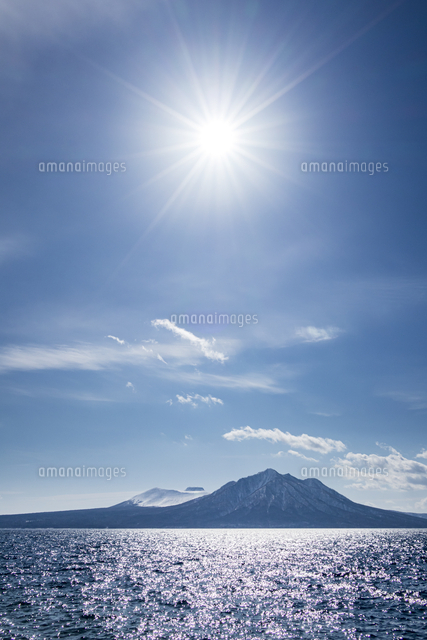 樽前山と風不死岳を照らす太陽[10983001369]の写真・イラスト素材