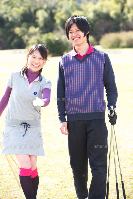 ゴルフクラブを持ってグリーンで指さす若いカップル の写真素材 イラスト素材 アマナイメージズ