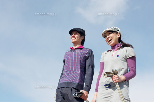 青空バックでゴルフクラブを持って歩く若いカップル の写真素材 イラスト素材 アマナイメージズ