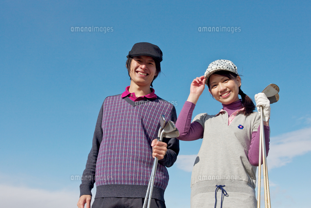 青空バックでゴルフクラブを持って微笑むカップル の写真素材 イラスト素材 アマナイメージズ