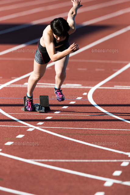 陸上トラックで走り出す女性 の写真素材 イラスト素材 アマナイメージズ