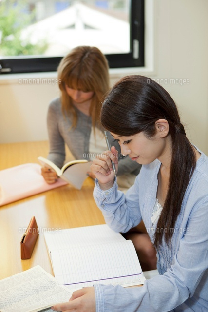 机に向かって勉強する大学生と留学生 の写真素材 イラスト素材 アマナイメージズ