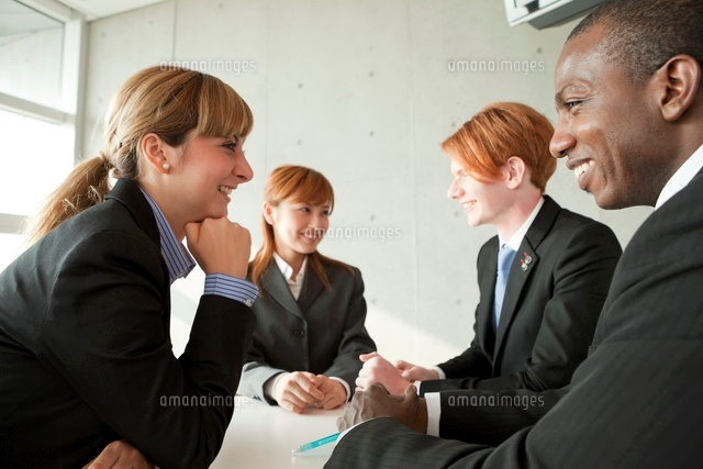 談笑するスーツ姿の男女４人 の写真素材 イラスト素材 アマナイメージズ