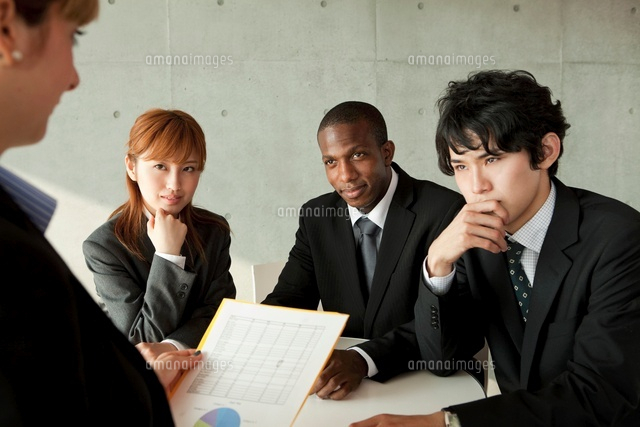 資料を検討するスーツ姿の男女4人 の写真素材 イラスト素材 アマナイメージズ