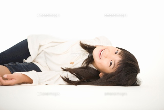 笑顔で横になっている女の子 の写真素材 イラスト素材 アマナイメージズ