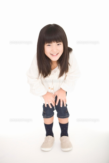 笑顔でかがむ女の子 の写真素材 イラスト素材 アマナイメージズ