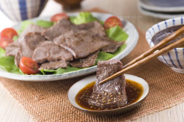 焼肉にたれをつける の写真素材 イラスト素材 アマナイメージズ