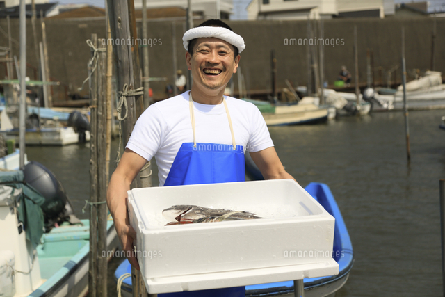 港でトロ箱を抱える鮮魚店店員 の写真素材 イラスト素材 アマナイメージズ