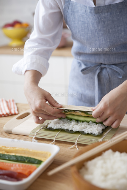 巻き簾で海苔と酢飯を巻いて太巻を作る女性 の写真素材 イラスト素材 アマナイメージズ