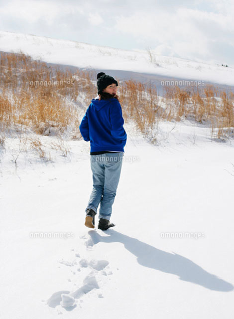雪道を歩く女性の後ろ姿 の写真素材 イラスト素材 アマナイメージズ