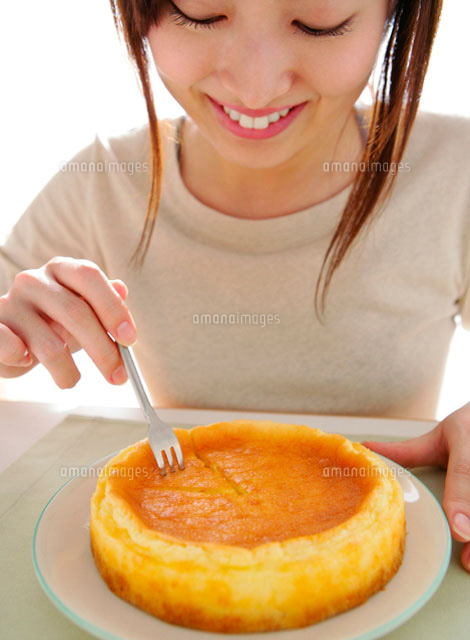 ケーキをフォークにさす女性 の写真素材 イラスト素材 アマナイメージズ