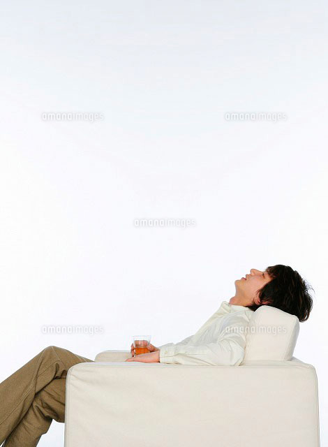 ソファーに腰掛ける男性 の写真素材 イラスト素材 アマナイメージズ