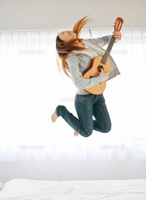 ギターを持ち飛び跳ねる女性 の写真素材 イラスト素材 アマナイメージズ