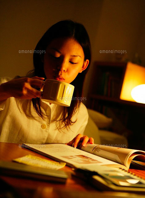 暗い部屋でコップを持つ日本人女性 の写真素材 イラスト素材 アマナイメージズ