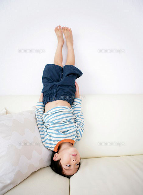 ソファーの上で逆立ちをする男の子 の写真素材 イラスト素材 アマナイメージズ