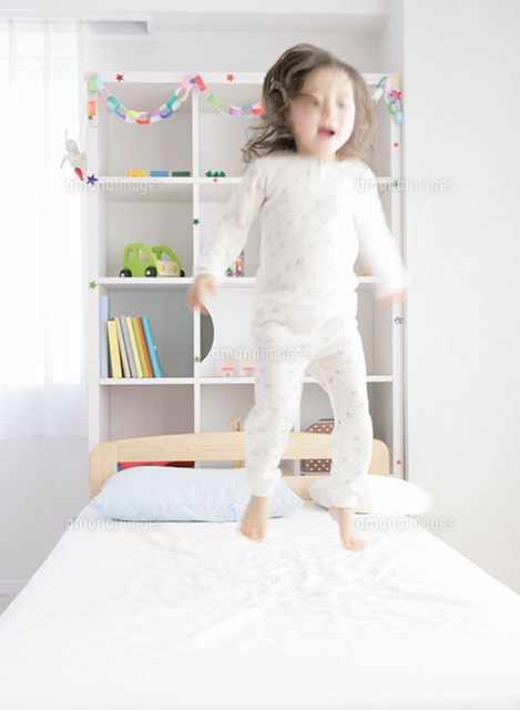 ベッドで飛び跳ねる女の子 の写真素材 イラスト素材 アマナイメージズ