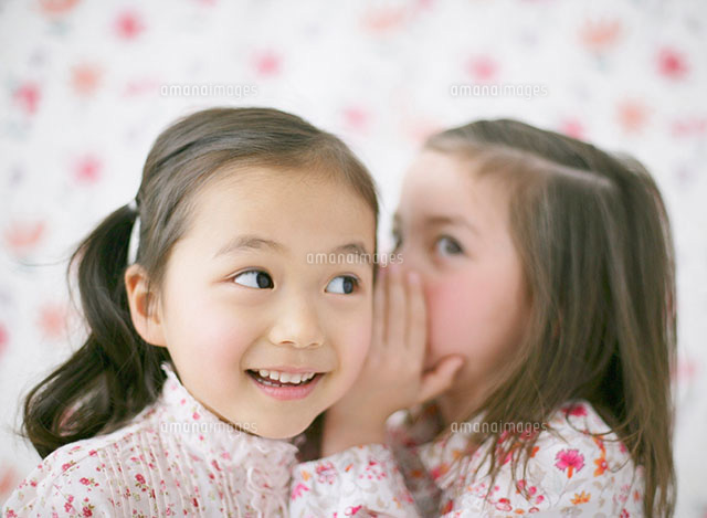 耳打ちをする二人の女の子 の写真素材 イラスト素材 アマナイメージズ
