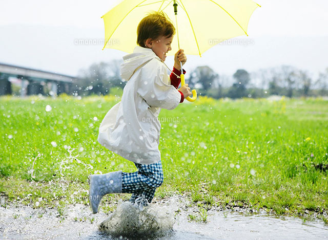黄色い傘をさして走る男の子 の写真素材 イラスト素材 アマナイメージズ