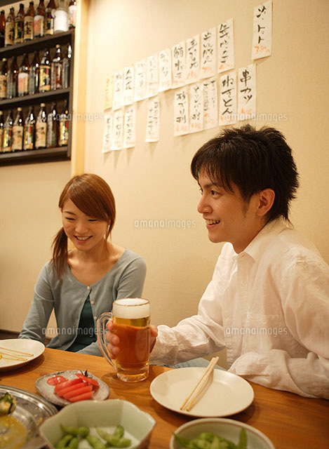 居酒屋で談笑するカップル の写真素材 イラスト素材 アマナイメージズ