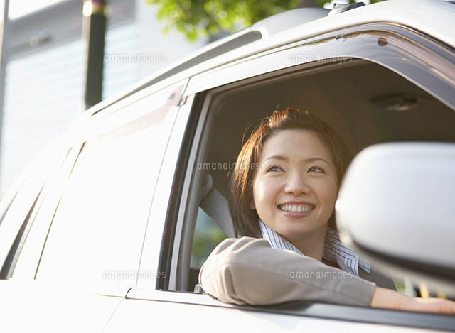 車の窓から外を眺める笑顔の女性 の写真素材 イラスト素材 アマナイメージズ