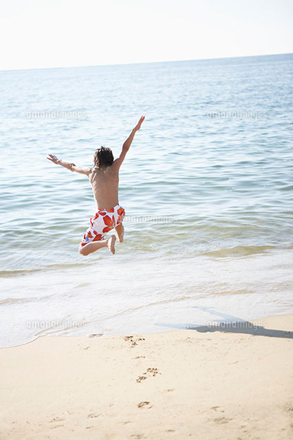 海に向かってジャンプする男の子 の写真素材 イラスト素材 アマナイメージズ
