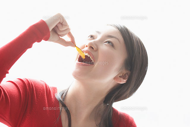 つまみ食いをする女性 の写真素材 イラスト素材 アマナイメージズ