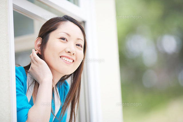 窓から身を乗り出す女性 の写真素材 イラスト素材 アマナイメージズ