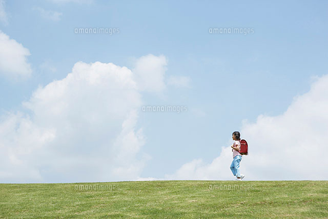 草原を歩く女の子 の写真素材 イラスト素材 アマナイメージズ