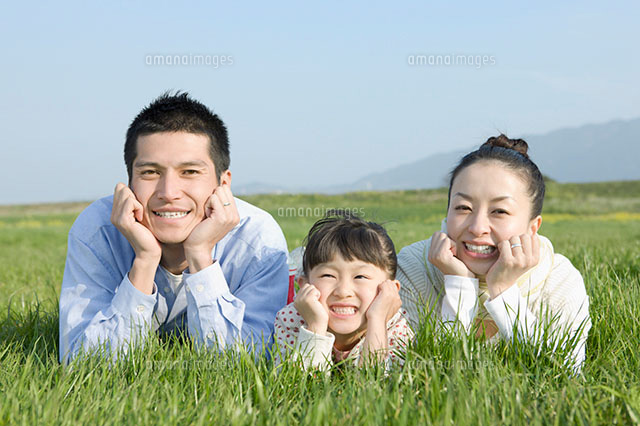 草原で寝転ぶ日本人の家族 の写真素材 イラスト素材 アマナイメージズ