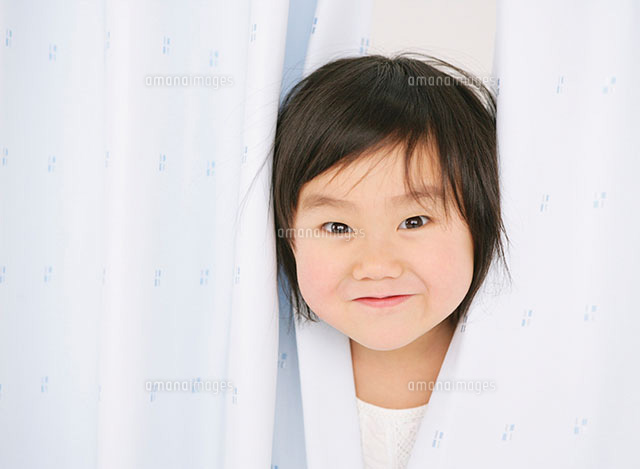 カーテンから顔を覗かせる女の子 の写真素材 イラスト素材 アマナイメージズ