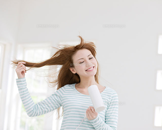 ドライヤーで髪を乾かす女性 の写真素材 イラスト素材 アマナイメージズ