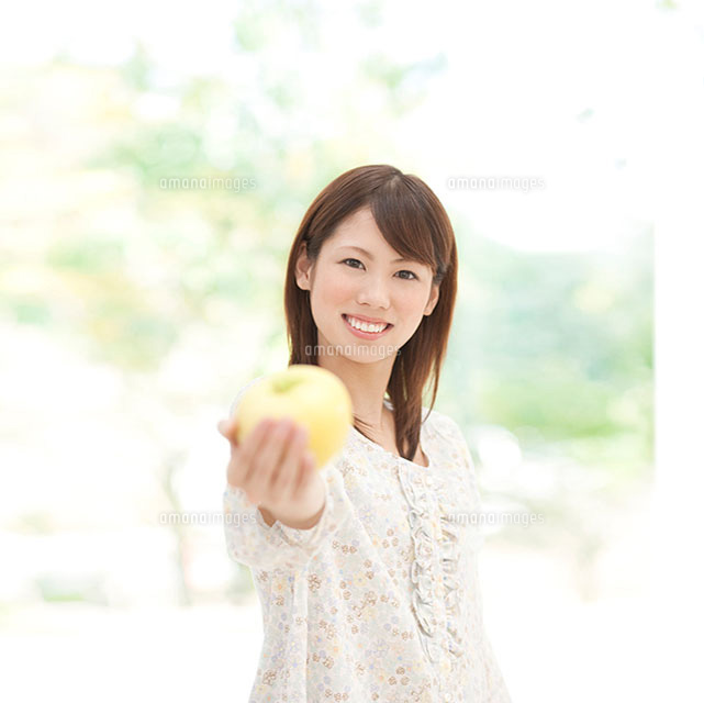 青リンゴを差し出す女性 の写真素材 イラスト素材 アマナイメージズ